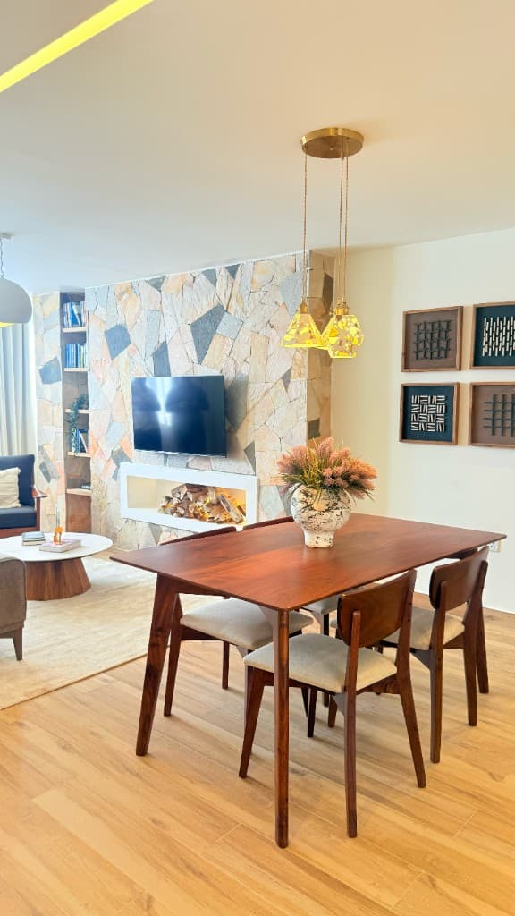 Open-plan living and dining space with stone feature wall